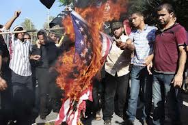A group of men burning an American flag during a protest.