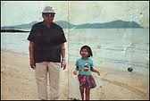 Pol Pot's little girl and her dad strolling on a beach in Phuket, Thailand in 1991