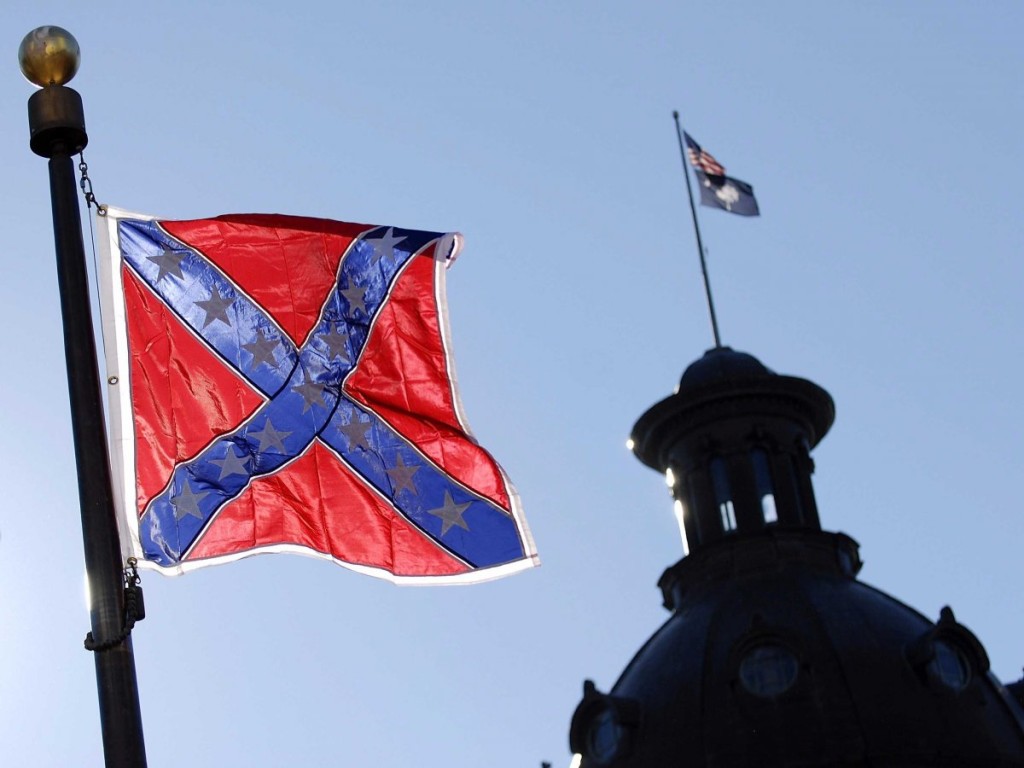In forefront the Confederate flag flying today at war monument in front of the South Carolina statehouse. In background is the state house dome which is flying the U.S. flag