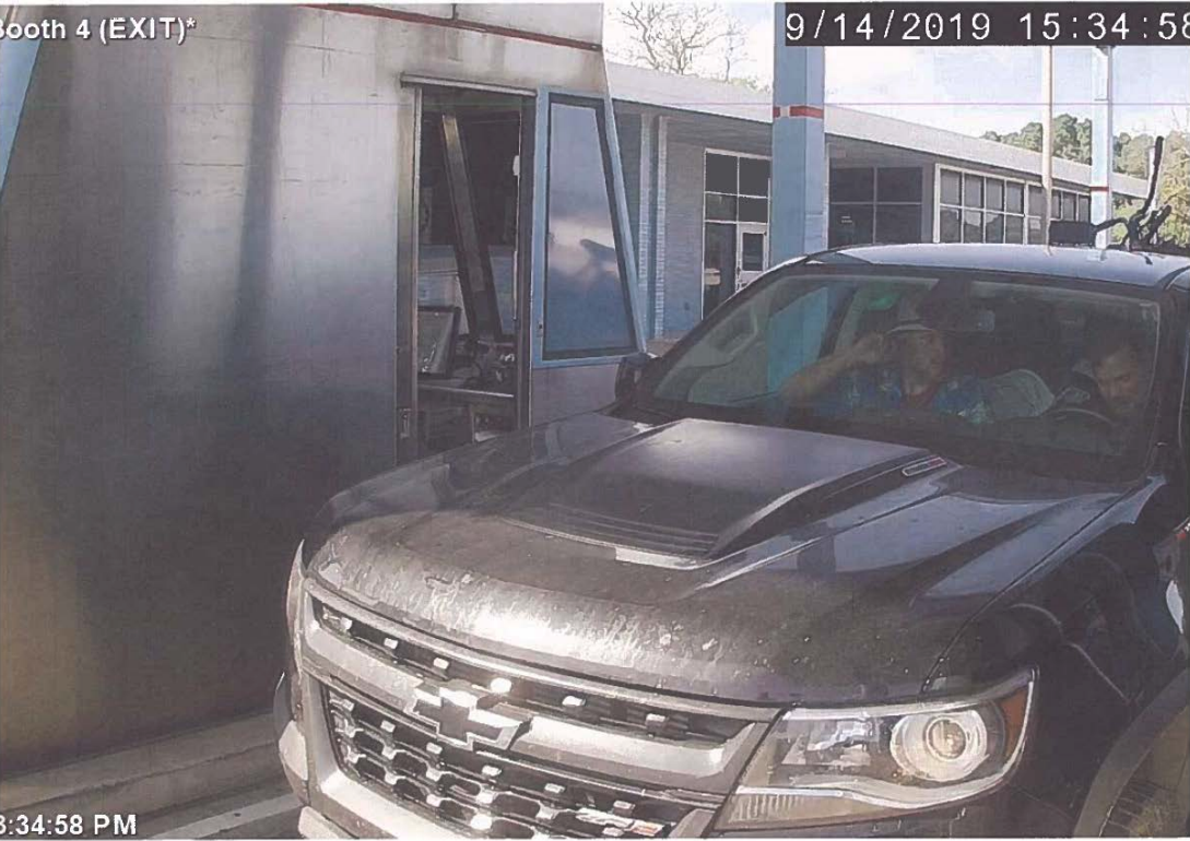 A surveillance camera capture of a black Chevrolet truck at an exit booth, dated September 14, 2019. Two individuals are visible inside the vehicle.