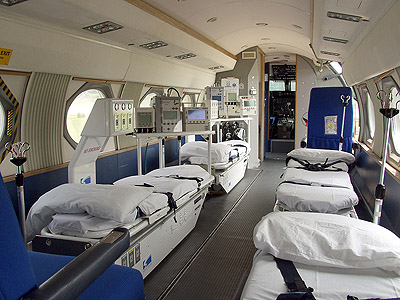 Interior of a medical evacuation aircraft showing multiple stretchers and medical monitoring equipment.