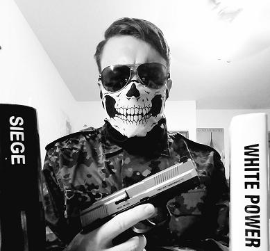 A black and white photograph of an individual wearing a skull-patterned face mask, aviator sunglasses, and camouflage clothing while holding a handgun. The person is positioned between two objects, one labeled 'SIEGE' and the other 'WHITE POWER'.