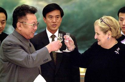 A photograph of North Korean leader Kim Jong Il and US Secretary of State Madeleine Albright clinking glasses during a toast, with several Asian officials in the background.