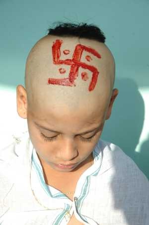 Swastika drawn on the head of a Hindu boy after his upanayam.