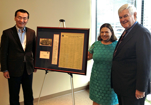 Newt Gingrich with an elected Mongolian parliamentarian in Washington displaying a framed copy of the