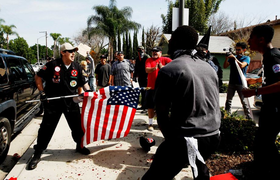 California Loyal White Knights of the KKK state leader William Quigg aka Billy Hagen wielding an American flag during confrontation with counter protestors today in California